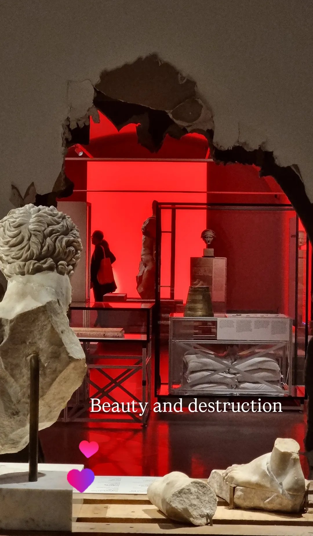 Red exhibition room with sculpture fragments