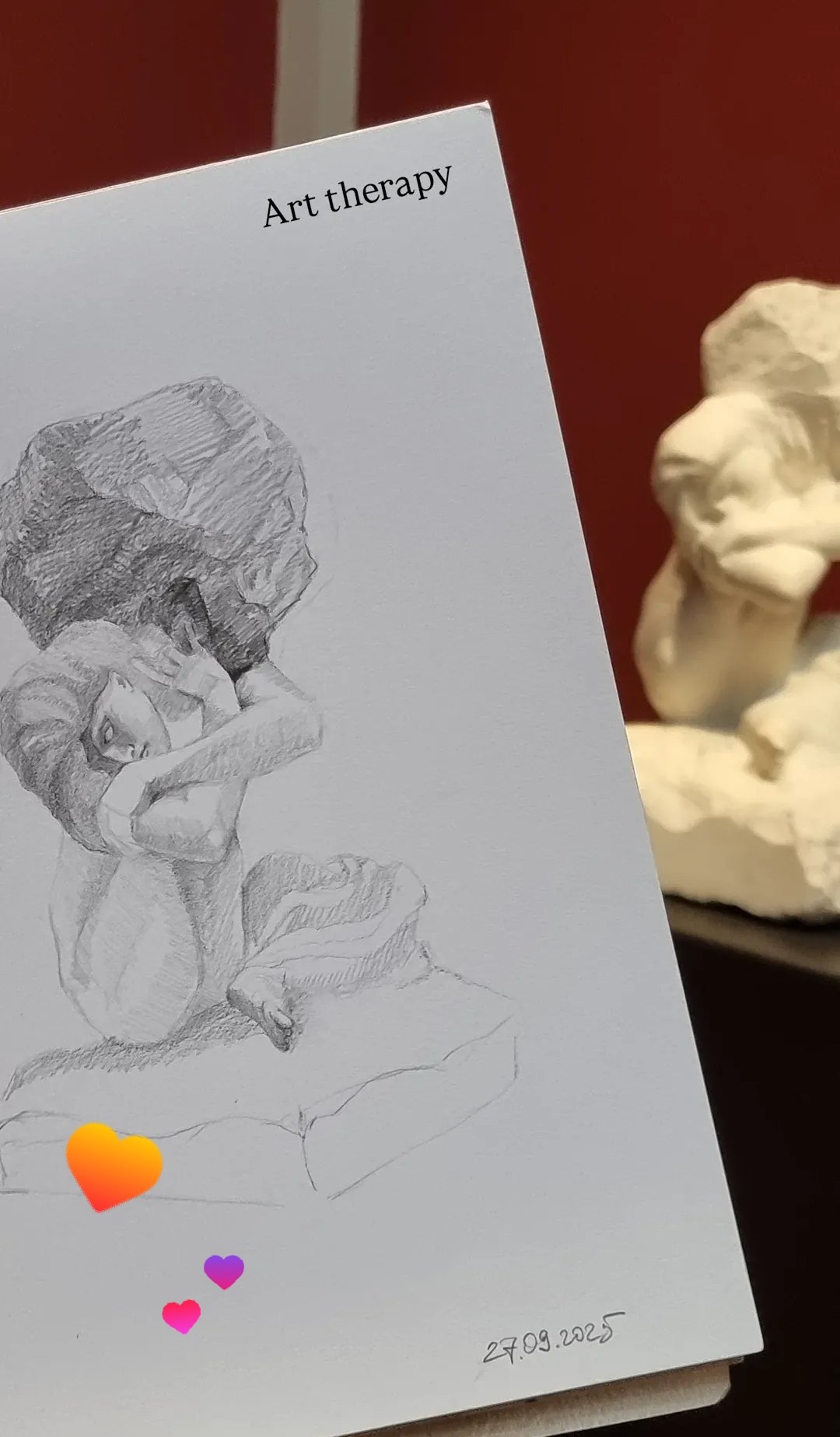 Sketchbook drawing beside sculptures